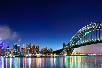 Fireworks at night over the Sydney Harbour with the skyline, Opera House, and bridge in view.